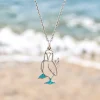 Blue-footed booby silver necklace hanging over a sandy beach